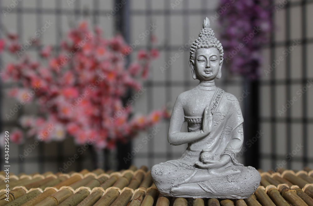 Buddha Statue in Asian Style Room With Cherry Blossoms in Background Buddha Statue in Asian Style Room With Cherry Blossoms in Background