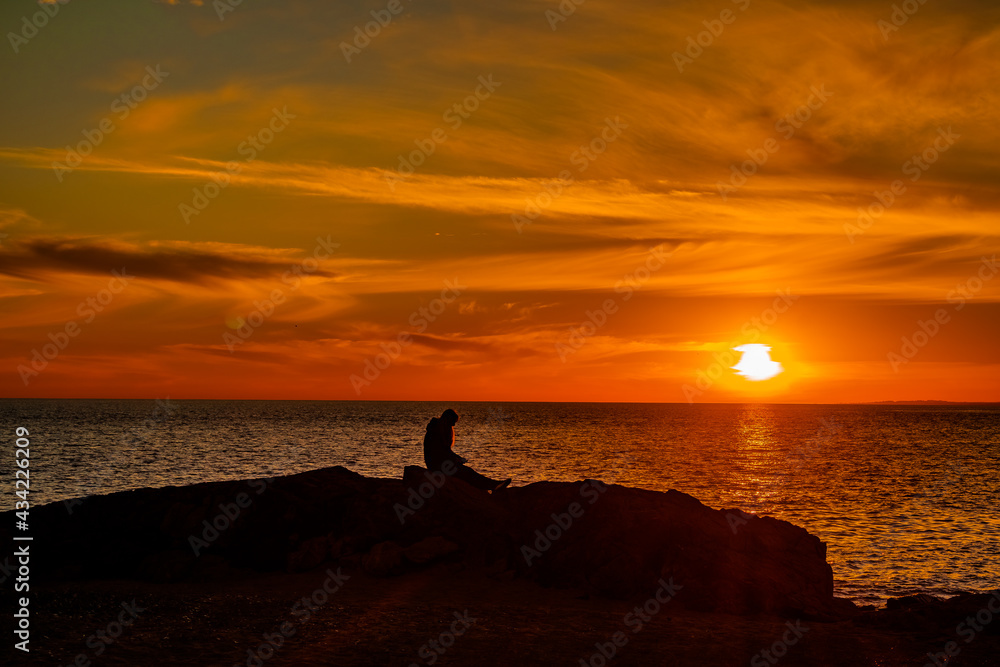 Persona contemplando un atardecer en el mar. Maldonado, Uruguay