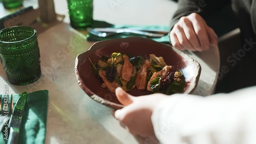Cafe scene of waitress bringing order to table with business coworkers. Mask wearing girl putting dish on table. Colleagues discussing work, talking about current situation. Concept of coronavirus