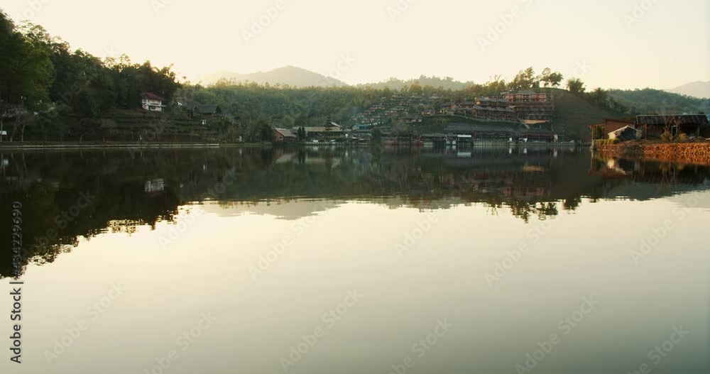 scenic landscape view of nature lake with reflection on surface and sunset sunlight in evening against village mountain hill on background at Ban Rak Thai village, Mae hong son, Northern Thailand scenic landscape view of nature lake with reflection on surface and sunset sunlight in evening against village mountain hill on background at Ban Rak Thai village, Mae hong son, Northern Thailand