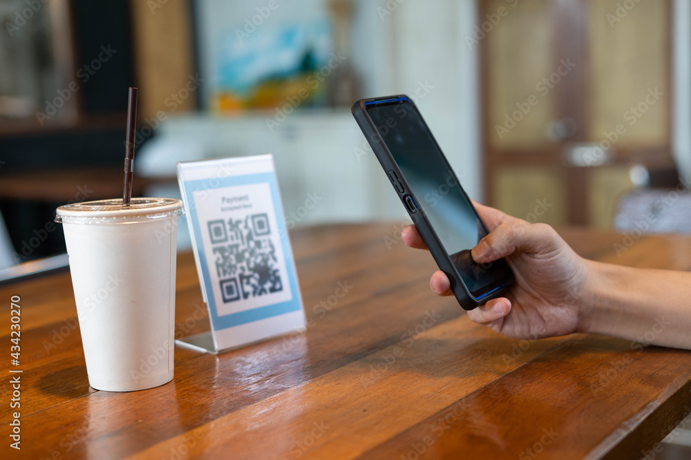 Men use phones to scan a qr code to select a menu or scan to receive a discount or pay for food and drink inside a cafe. using the phone to transfer money or pay online without cash concept. - obrazy, fototapety, plakaty 