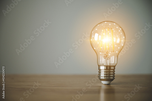 Light bulb on wood table with copy space. Concept of inspiration creative idea thinking and future technology innovation