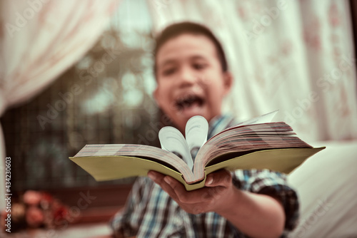 A boy giving books to camera