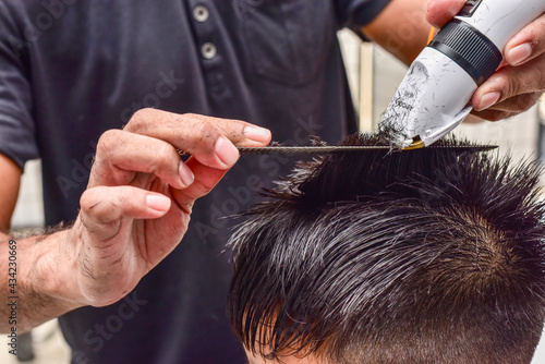 BURIRAM,THAILAND - MAY 14,2017: Unidentified Teenager boy's grooming trimmer in a beauty salon.Thai boy must to cut short before back to school.