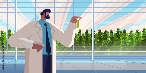 agricultural engineer holding test tube with chemicals man farmer researching plants in greenhouse agriculture scientist