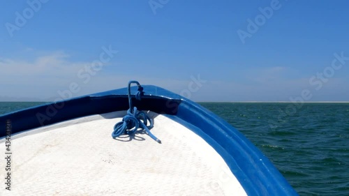 A bumpy ride at the bow of a small ocean boat cruising through the blue Magdelena Bay water photo
