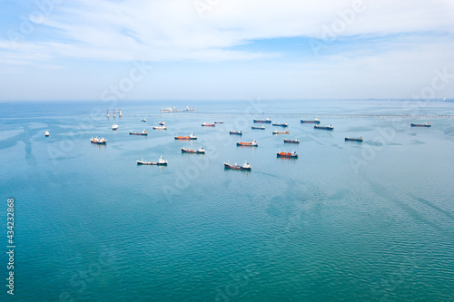 Aerial view from drone, Oil tanker ships off the coast in beautiful peaceful environment, professional business logistics and transportation of energy fuels.
