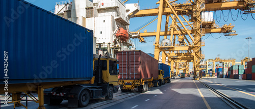 crane loading container box from truck to container cargo freight ship in port shipping containers a logistics business and global trading. logistics, global business and transportation concept