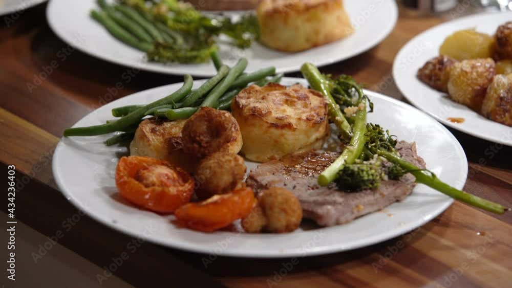 Grilled steak dish with potatoes, green vegetables and tomatoes