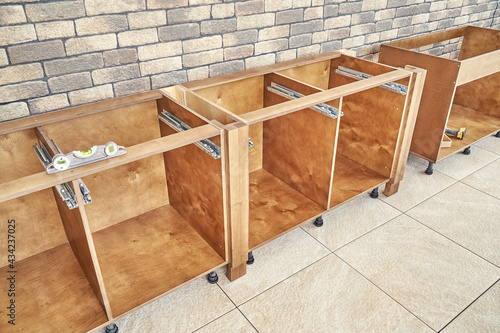 Tableau sur toile Wooden cases of kitchen furniture made of plywood and solid wood ash installed a