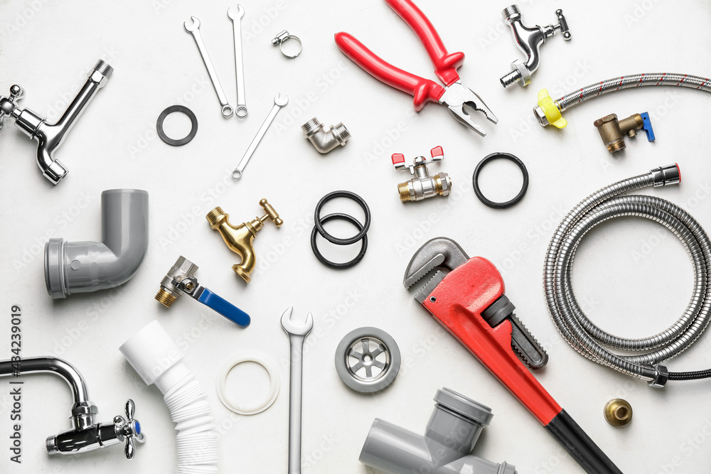 Set of plumber's items on light background