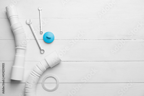 Set of plumber's items on light wooden background