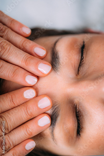 Craniosacral Therapy Massage. Therapist Massaging Woman’s Forehead.