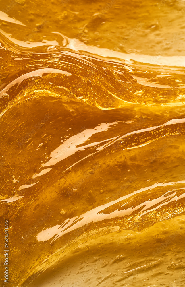 Transparent yellow smear of face cream or golden honey isolated on white background. Golden creamy texture on white background. Transparent yellow smear of face cream or golden honey isolated on white background. Golden creamy texture on white background.