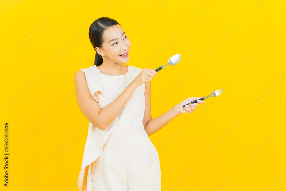 Portrait beautiful young asian woman smile with spoon and fork Portrait beautiful young asian woman smile with spoon and fork