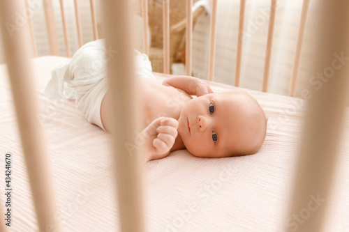 newborn baby lies in the crib