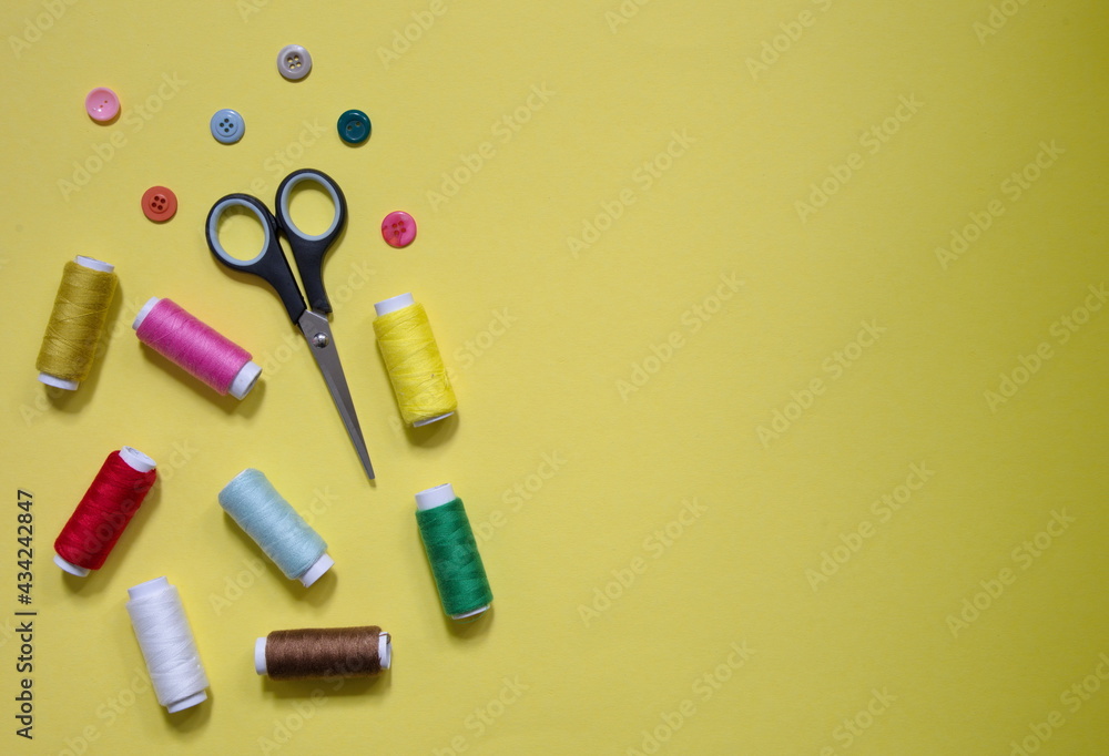 High angle view of sewing items on yellow background High angle view of sewing items on yellow background
