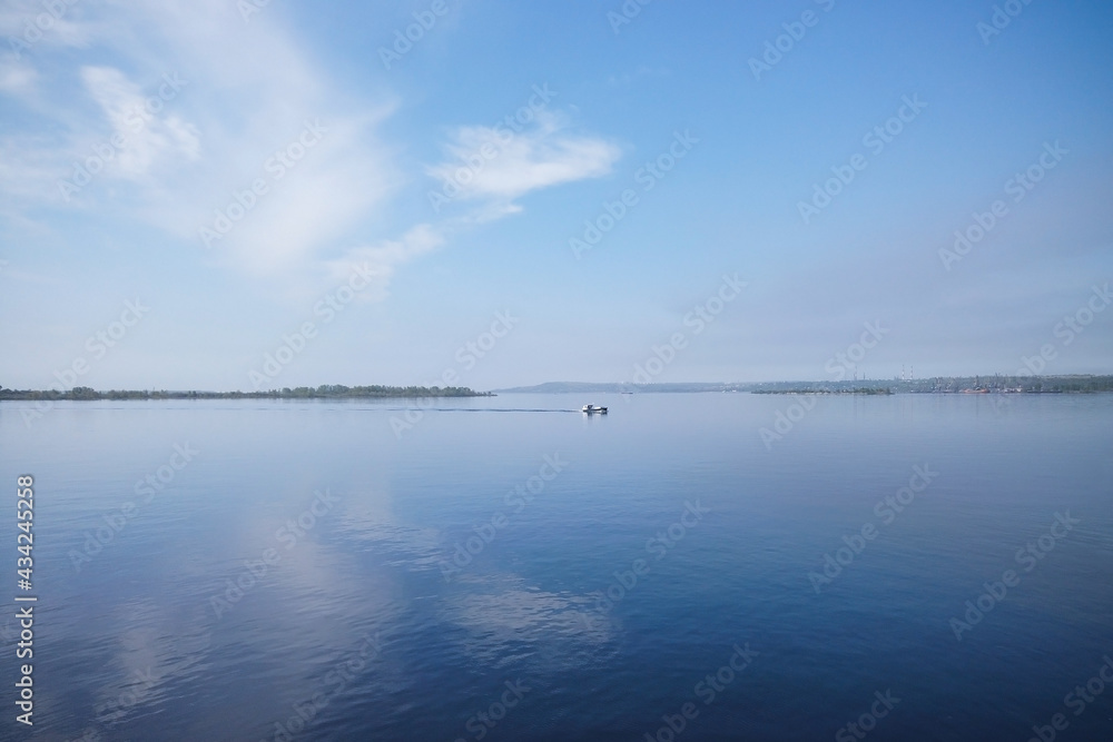 A motor boat sails from the island forward on a cloudy spring day A motor boat sails from the island forward on a cloudy spring day
