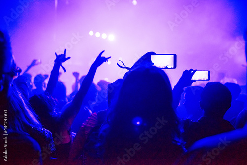Fototapeta Naklejka Na Ścianę i Meble -  Raised arms holding smart phones to recording a live concert