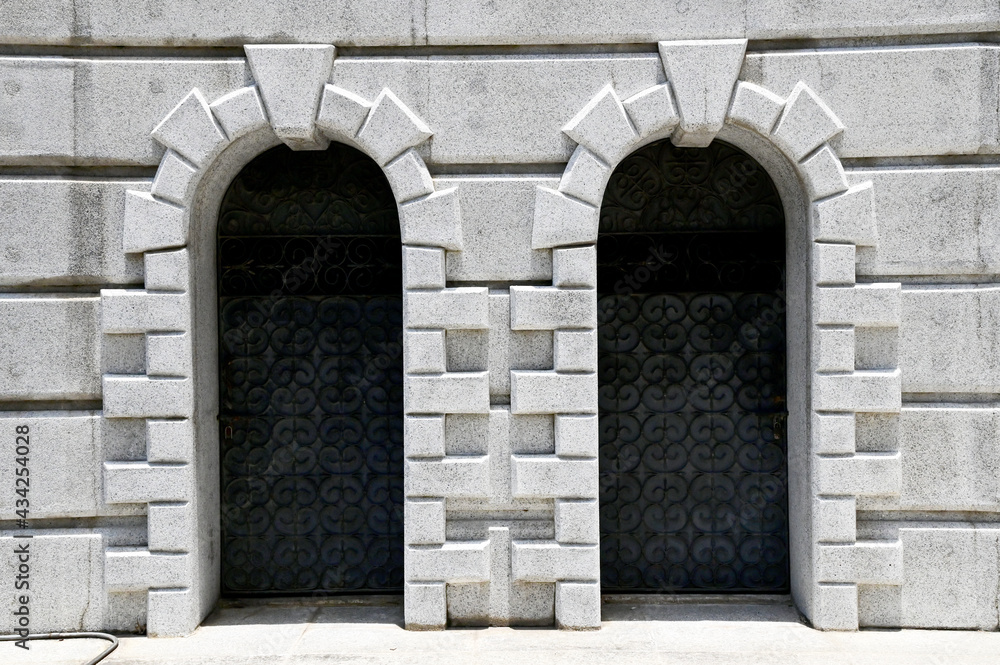 Closed Black wrought iron door on small gravel wall texture pattern background at Thailand.