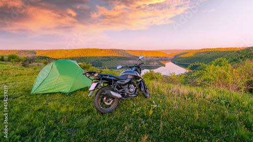 Motorcycle traveling concept, camping with a tent, scenic nature landscape with canyon in the national nature park Podilski Tovtry, Studenytsia and Dnister river, Ukraine photo