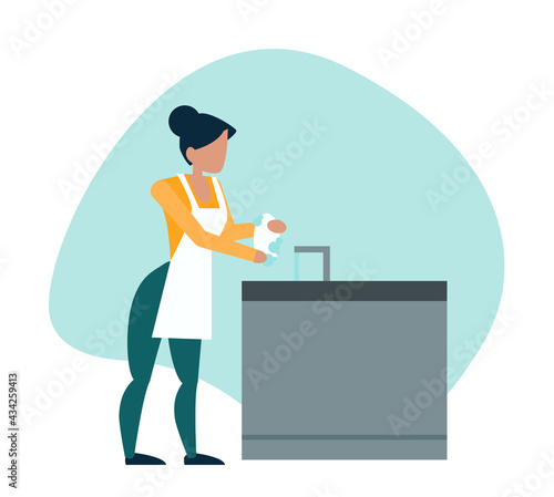 woman is doing dishes in the kitchen
