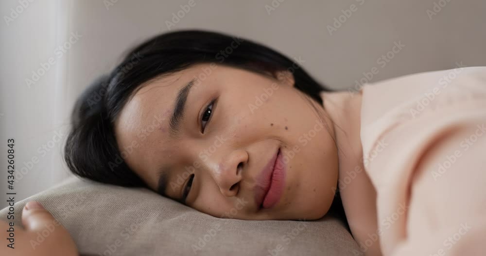 Thai woman laying in bed looking at camera. Thai woman laying in bed looking at camera.