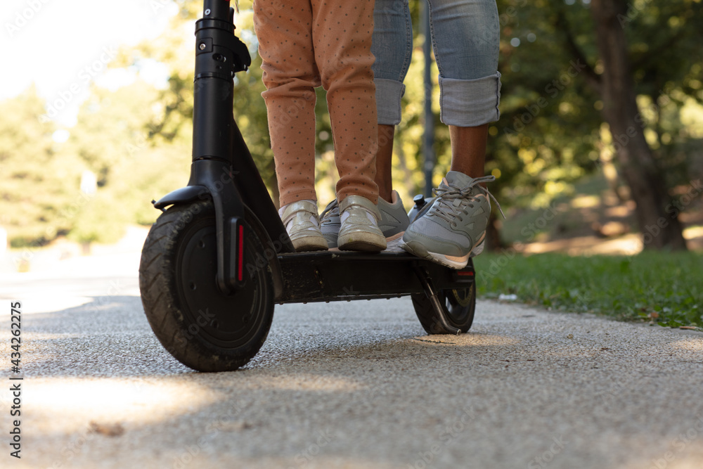 Obraz premium Mother and kid on electric scooter.
