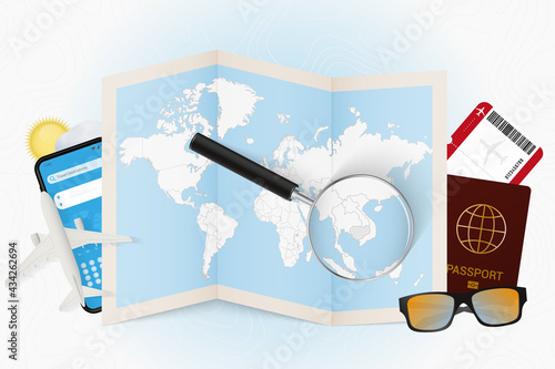Travel destination Cambodia, tourism mockup with travel equipment and world map with magnifying glass on a Cambodia.
