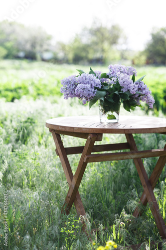 Εκτύπωση καμβά bouquet of lilacs on the table in the summer garden