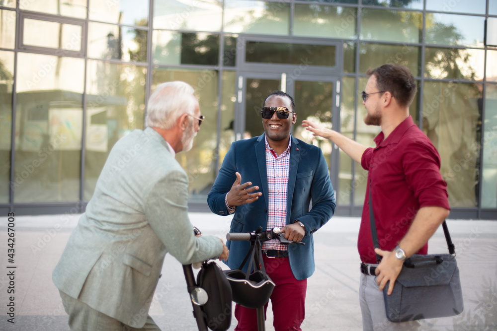 Three business colleagues standing outdoors and discussing. Three business colleagues standing outdoors and discussing.