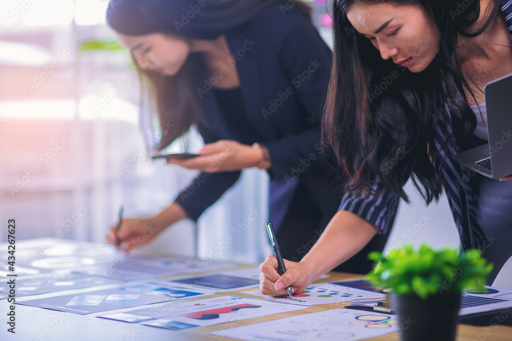 Fototapeta premium Businesswomen teamwork meeting concept. Analysis data, making a short note for start up new project in office.
