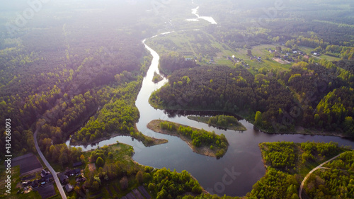 A view from a height of a beautiful curved blue river. Summer water landscape with forest