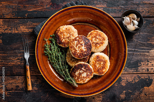Fried pork and beef meat cutlets or patty in a rustic  plate. Dark wooden background. Top view