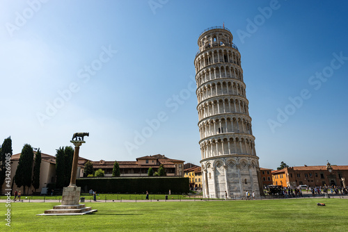 Leaning Tower of Pisa, bell tower of the Cathedral (Duomo di Santa Maria Assunta), Piazza dei Miracoli (Square of Miracles). Tuscany, Italy, Europe. On the left the monument of the she-wolf of Rome.