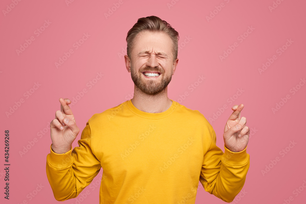 Man with crossed fingers on pink background Man with crossed fingers on pink background