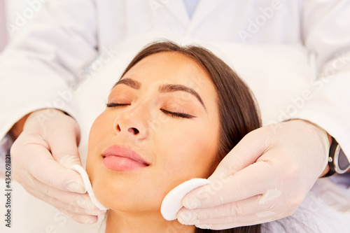 Kosmetiker reinigt Gesicht einer jungen Frau