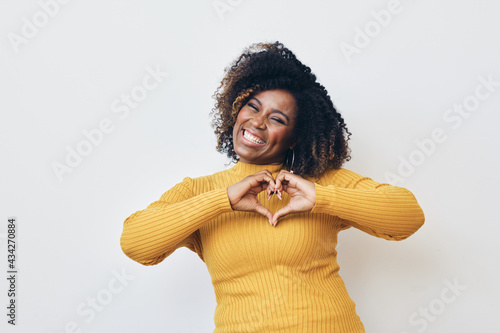 Happy African-American woman making heart with hands photo