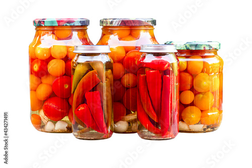 Tomatoes and peppers in glass jars, homemade pickles