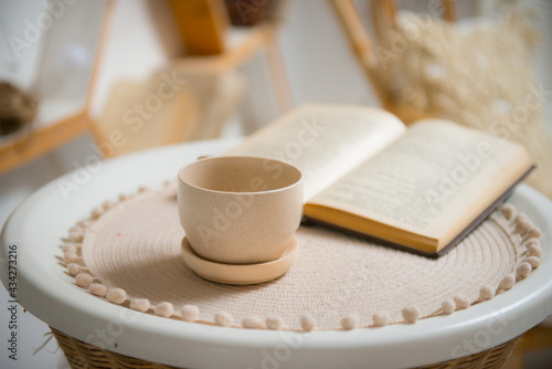 Clay cup and saucer on a rattan curbstone. Close-up.