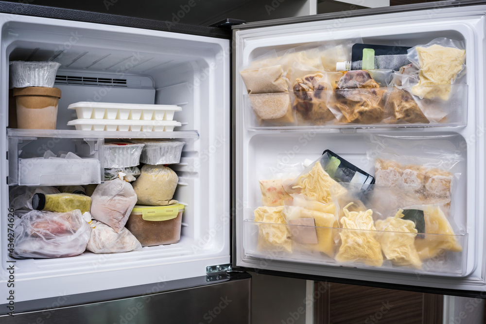 freezer of modern frigerator full with frozen food products in quarantine or work from home period during coronavirus pandemic freezer of modern frigerator full with frozen food products in quarantine or work from home period during coronavirus pandemic