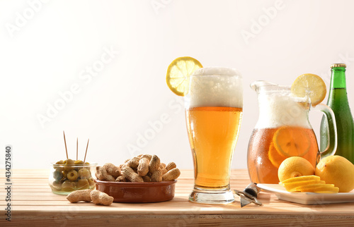 Leinwand Poster Beer with lemon and snacks on wooden table isolated background
