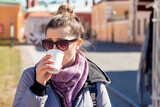 Portrait happy young tourist woman with coffee looking away