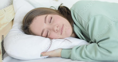 Young beautiful woman is falling with her head on the pillow tired and falling asleep. Close-up.