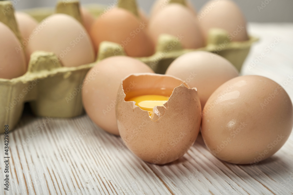 Close-up view of raw chicken eggs in egg box on wooden background. Raw chicken eggs in egg box organic food for good health high protein . Close-up view of raw chicken eggs in egg box on wooden background. Raw chicken eggs in egg box organic food for good health high protein .