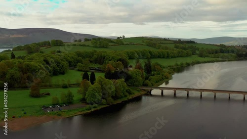 Aerial drone view over  Irish landscape at sunrise revealing the Baltyboys bridge and Liffey river on a cloudy day. photo