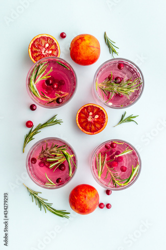 Glasses of refreshing lemonade with cranberries and red oranges