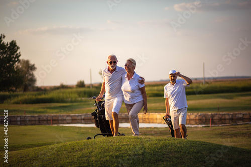 Three senior golfers. Focus is on man and woman. Three senior golfers.