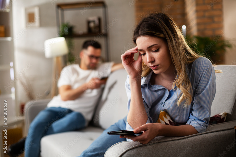 Happy young woman using the phone at home. Excited woman enjoying in the living room.. Happy young woman using the phone at home. Excited woman enjoying in the living room..