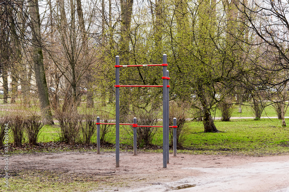 An empty gymnastic horizontal bar in a city park in early spring
